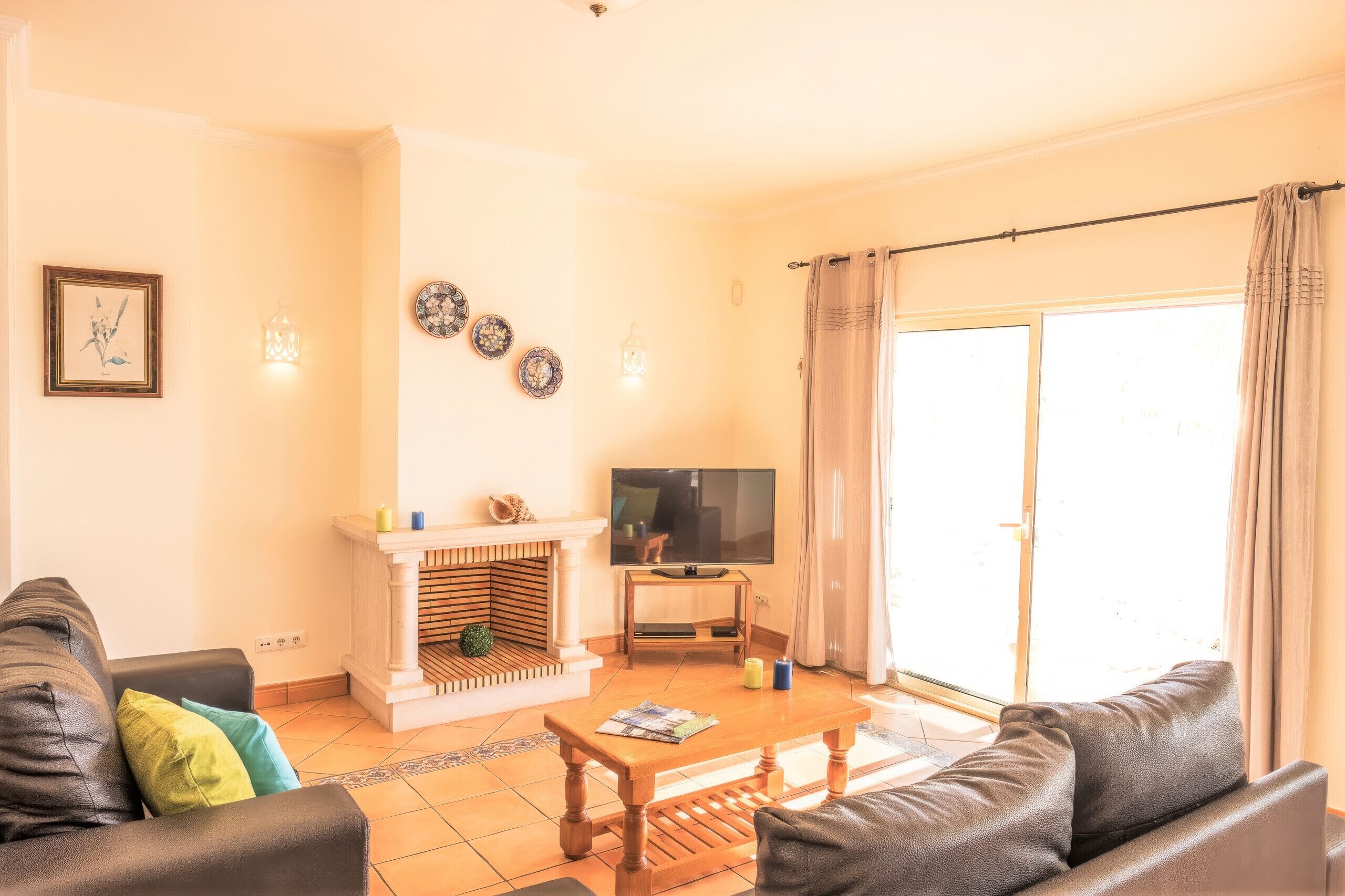 A living room with a fireplace, a television, and a sofa.