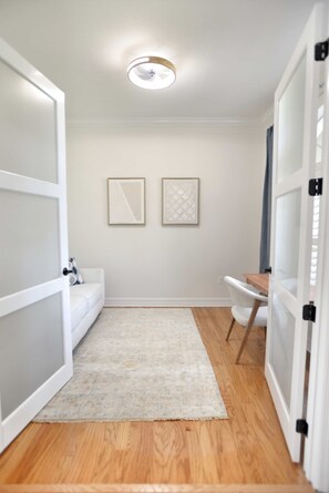 A hallway with a white couch, a small table, and two framed artworks on the wall. - Perfect 4-bedroom house with heated pool in Rotonda West for large families! (Rotonda West)