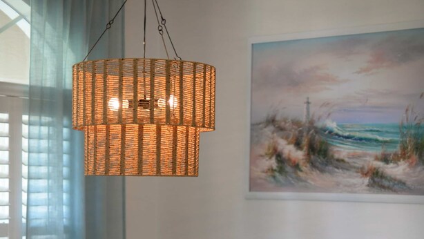 A dining area with a table, chairs, a bench, a decorative light fixture, and a painting on the wall. - Perfect 4-bedroom house with heated pool in Rotonda West for large families! (Rotonda West)
