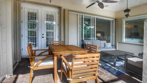 A dining area with a wooden table and chairs, a ceiling fan, and a view through a glass door. - Perfect 4-bedroom house with heated pool in Rotonda West for large families! (Rotonda West)