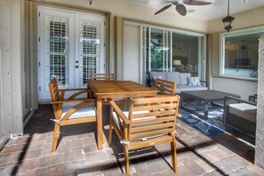 A dining area with a wooden table and chairs, a ceiling fan, and a view through a glass door. - Perfect 4-bedroom house with heated pool in Rotonda West for large families! (Rotonda West)