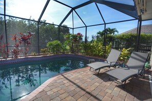 A swimming pool with a brick patio and lounge chairs. - Perfect 4-bedroom house with heated pool in Rotonda West for large families! (Rotonda West)
