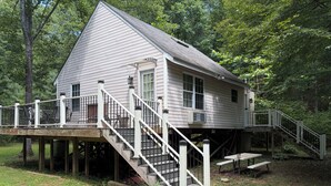 A two-story house with a deck and stairs leading to the upper level.