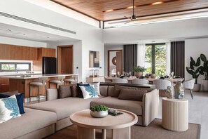 A modern living space with a kitchen, dining area, and seating area. - Botanica Foresta Luxury 4BR Villa • Private Pool (Thep Krasatti)