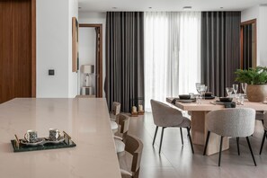 A modern dining area with a long table, chairs, and a potted plant. - Botanica Foresta Luxury 4BR Villa • Private Pool (Thep Krasatti)
