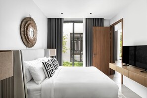 A modern bedroom with a large bed, a television, and a view of the outdoors. - Botanica Foresta Luxury 4BR Villa • Private Pool (Thep Krasatti)