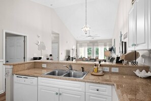 A kitchen with granite countertops, stainless steel sinks, and white cabinetry. - 2 bed 2 bath condo in Ocean Keyes, N. Myrtle Beach (North Myrtle Beach)