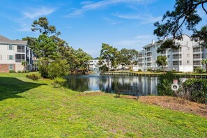 A residential area with a lake, a bench, and a lifebuoy. - 2 bed 2 bath condo in Ocean Keyes, N. Myrtle Beach (North Myrtle Beach)