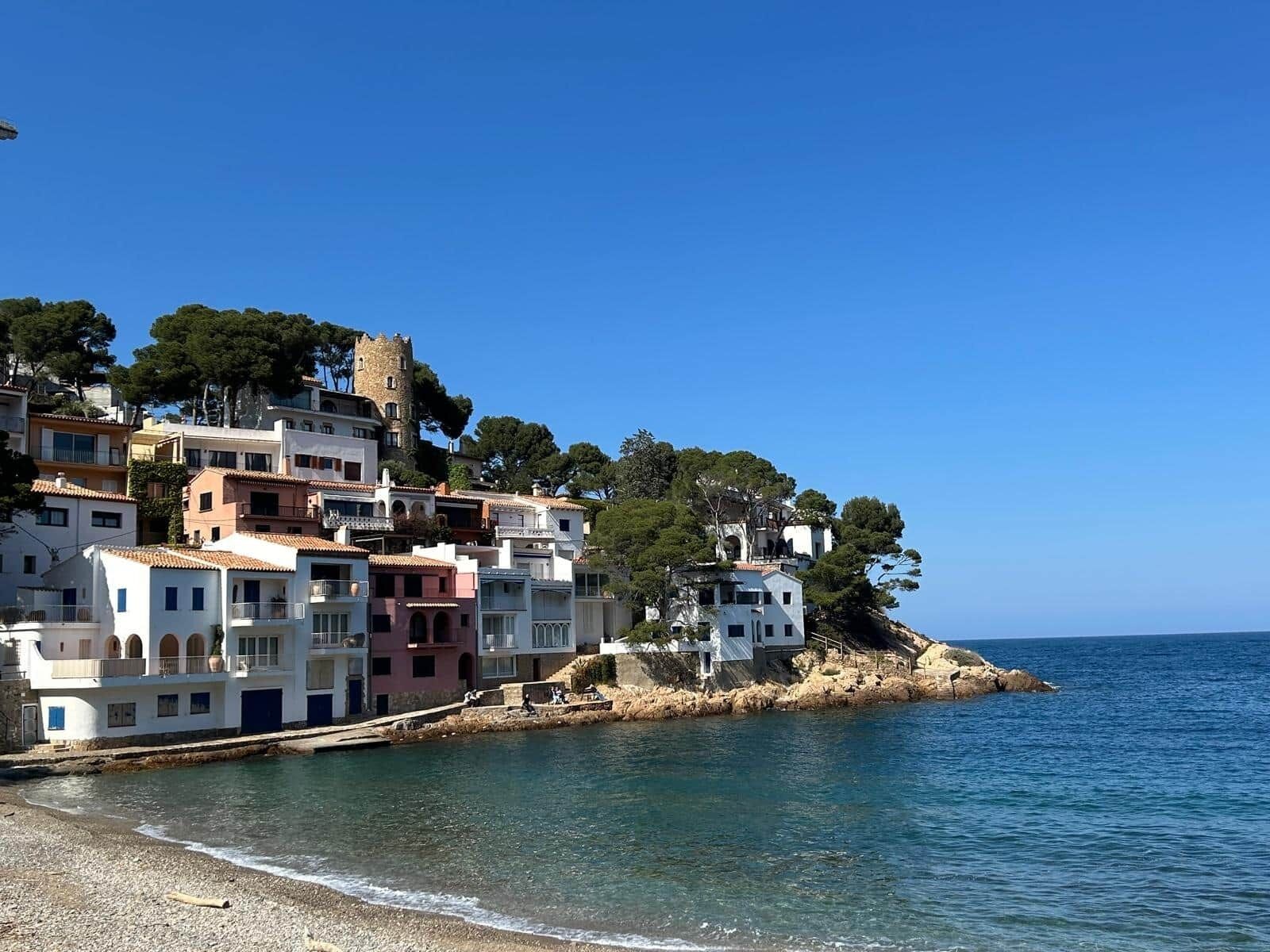 A coastal town with buildings built on a hillside overlooking the sea.