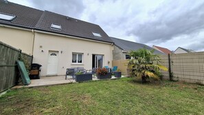 A residential property with a patio area, outdoor seating, and a fenced garden. - Charming house with an enclosed garden and a patio between Chartres and Rambouillet (Auneau)
