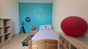 A bedroom with a bed, a red ball, a shelf, a lamp, and a wall clock. - Charming house with an enclosed garden and a patio between Chartres and Rambouillet (Auneau)