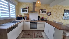 A compact kitchen with a gas stove, microwave, and a coffee machine. - Charming house with an enclosed garden and a patio between Chartres and Rambouillet (Auneau)