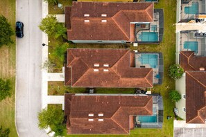Ein Wohngebiet mit drei Häusern, jeweils mit Schwimmbad und Garage.