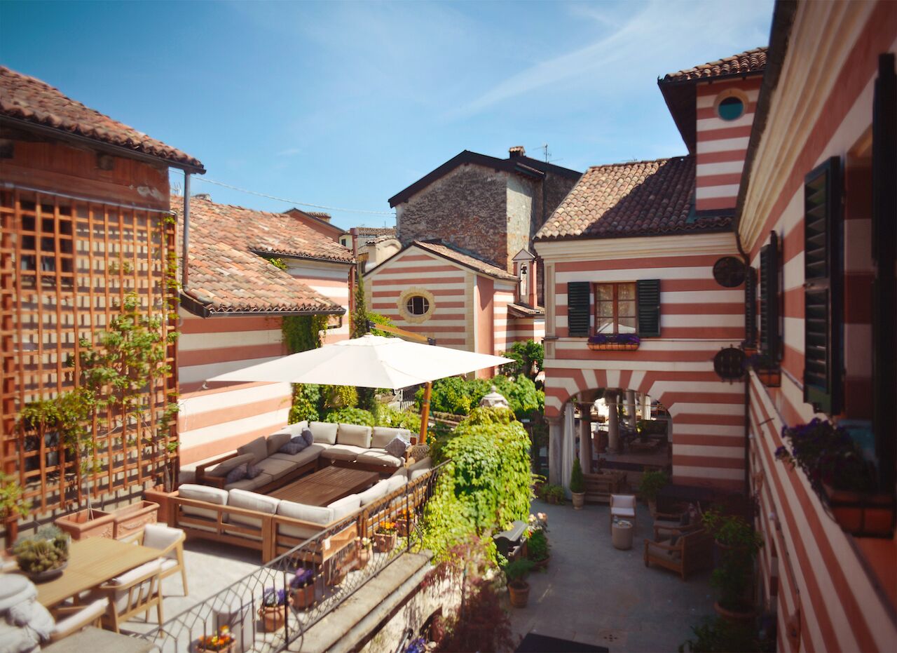 A courtyard with a seating area, a wooden fence, and a building with striped walls.
