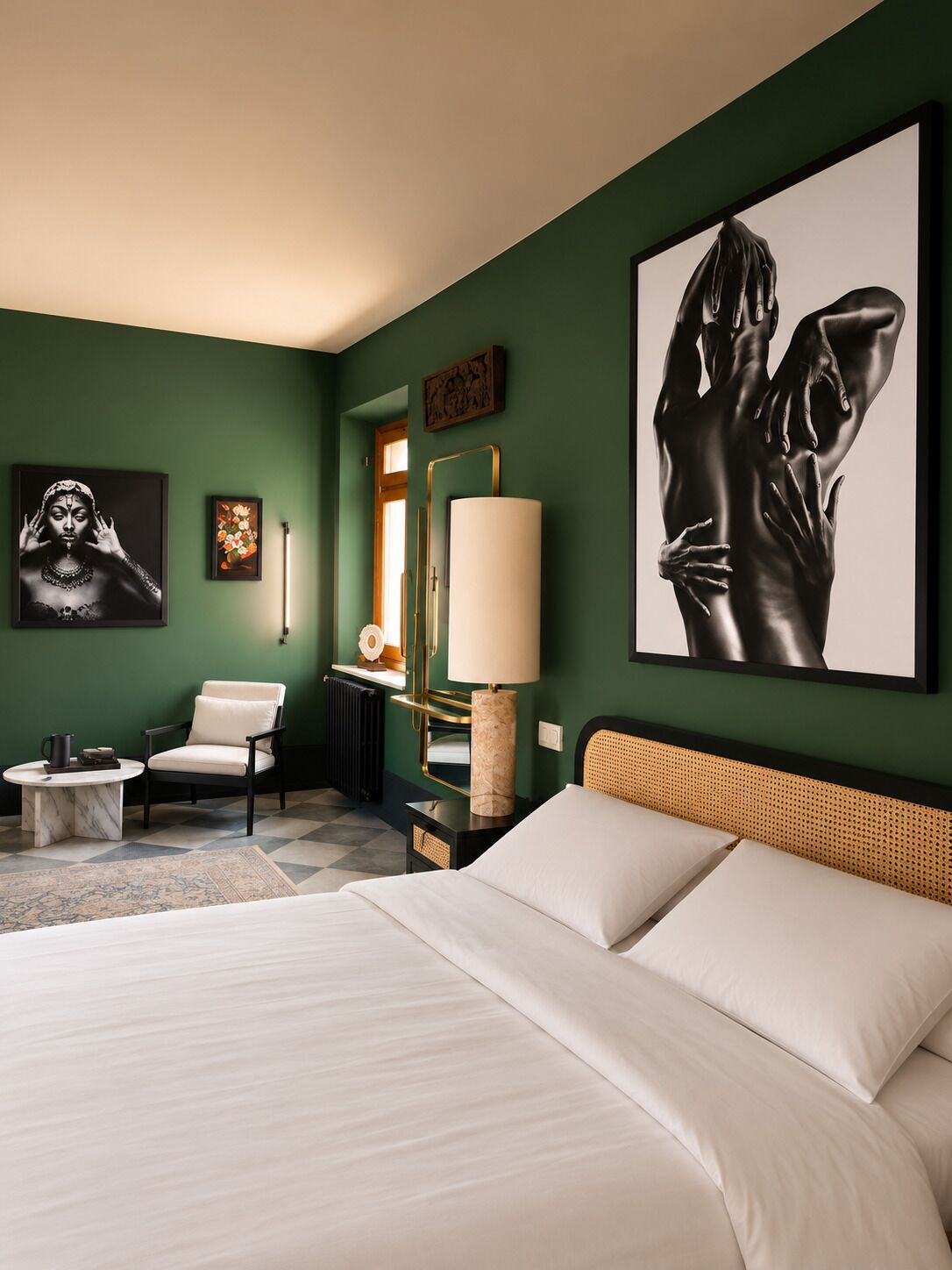 Una camera d'albergo con un letto, una sedia, una lampada e opere d'arte alle pareti.