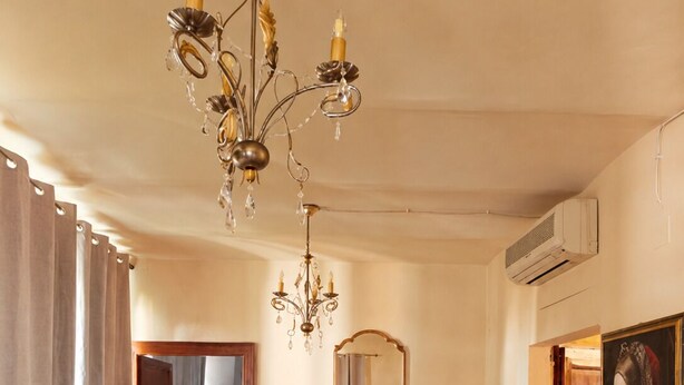 A hotel room with a bed, two chairs, a table, a chandelier, a mirror, and a painting. - Club Carpeneto  (Carpeneto)