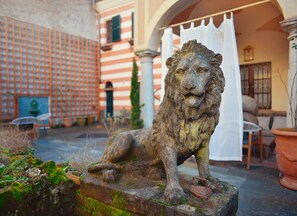 A lion statue in a courtyard with a building in the background.