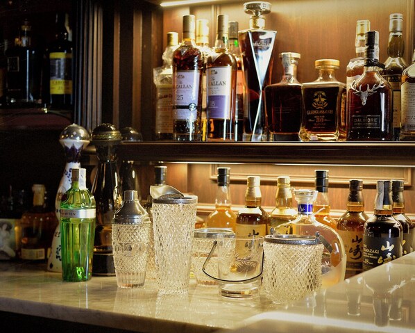A bar with various liquor bottles and crystal glasses.