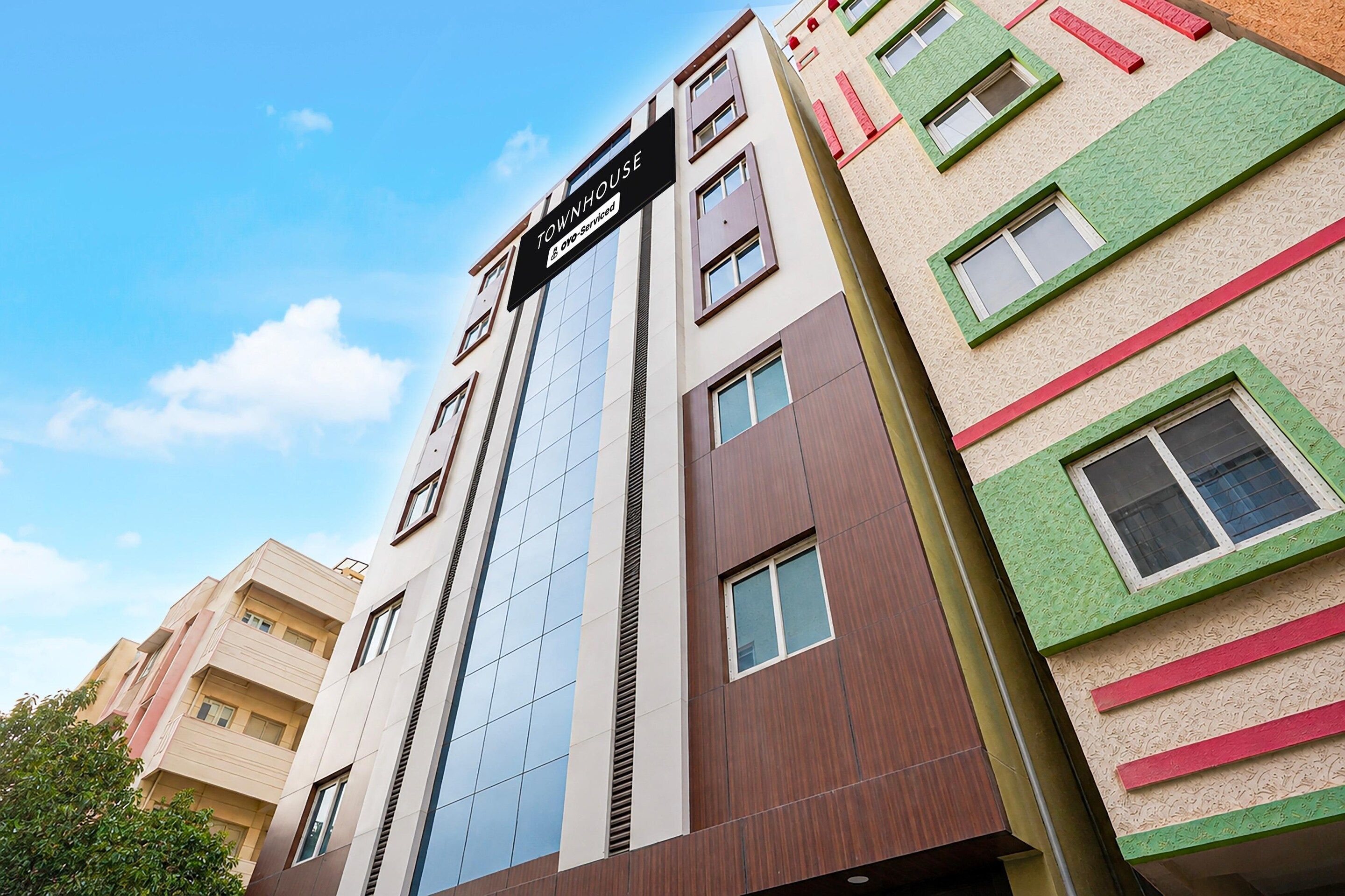A multi-story building with a sign indicating it is a serviced apartment.