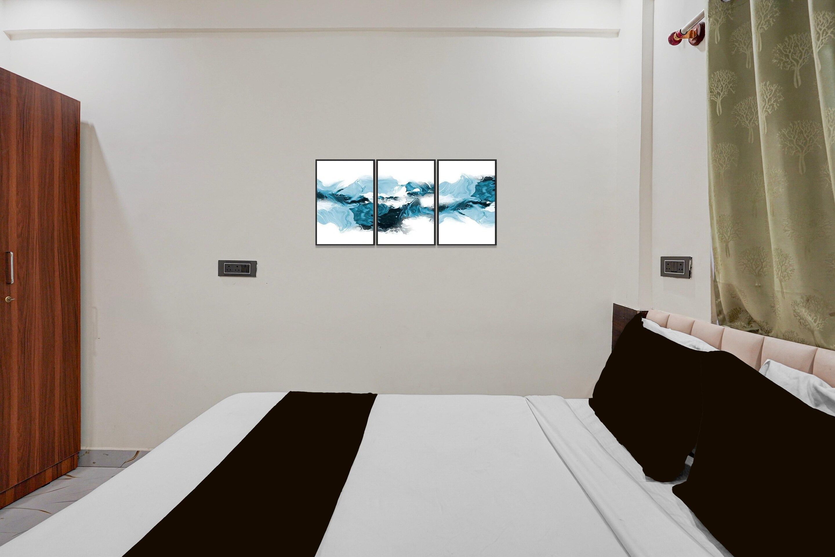 A bedroom with a bed, a wardrobe, a painting, and a curtain.