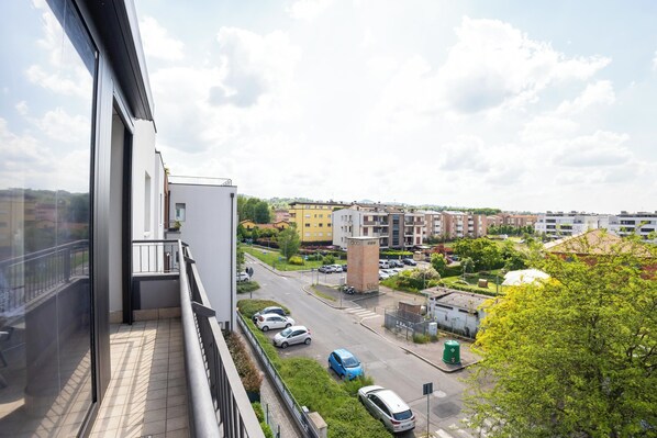 A residential area with a clear view of a street, parked cars, and buildings in the background.