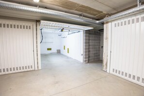 A corridor with lockers on both sides, a concrete floor, and a brick wall at the end. - Le Ninfee • Tourist Apartment (Zola Predosa)