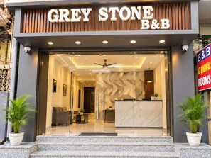 The entrance to Grey Stone B&B with a modern design, including a reception desk and seating area. - Hotel Grey Stone B & B (Amritsar)