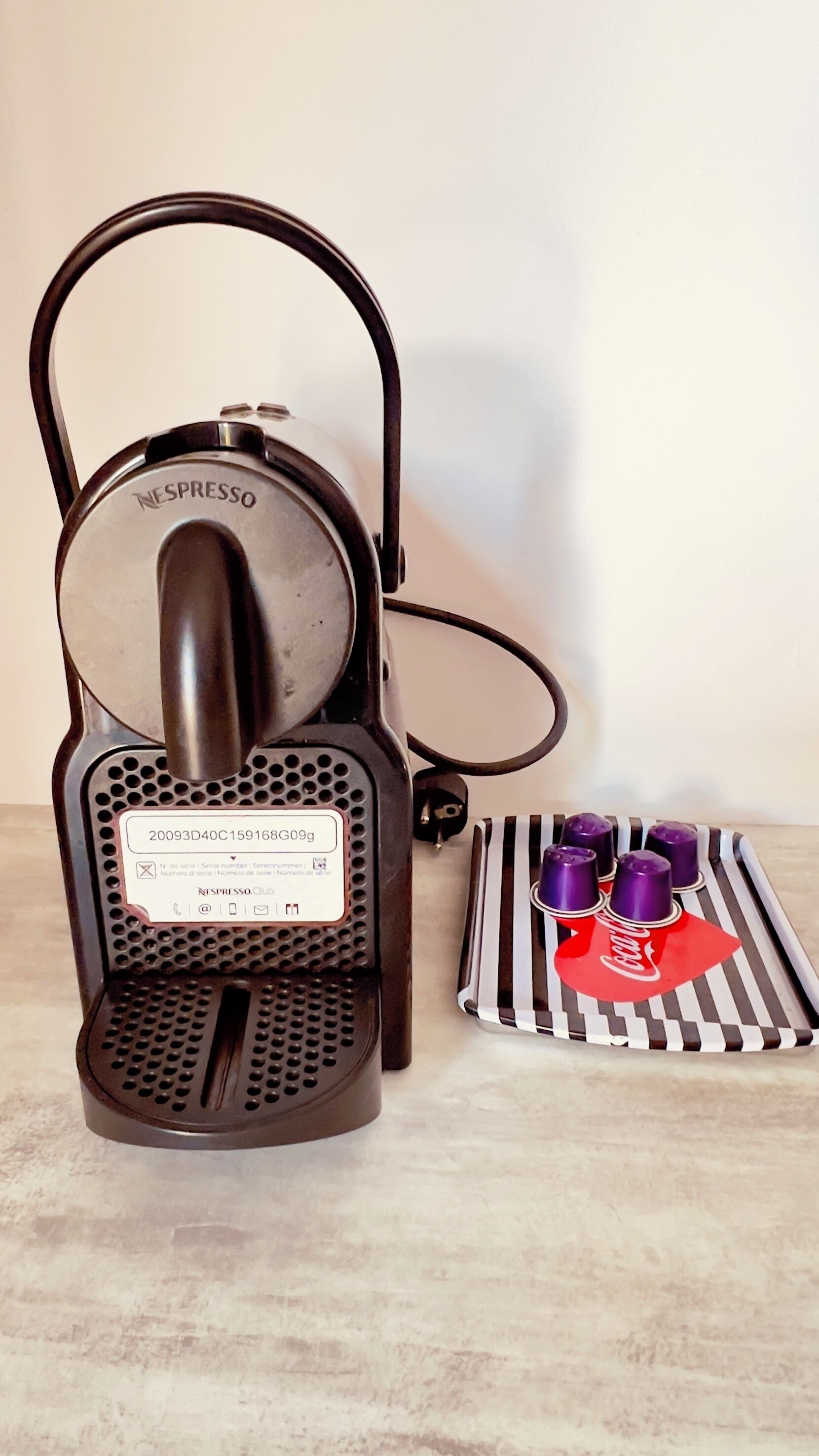 A Nespresso coffee machine with a drip tray and a set of coffee capsules.