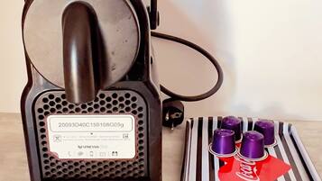 A Nespresso coffee machine with a drip tray and a set of coffee capsules.