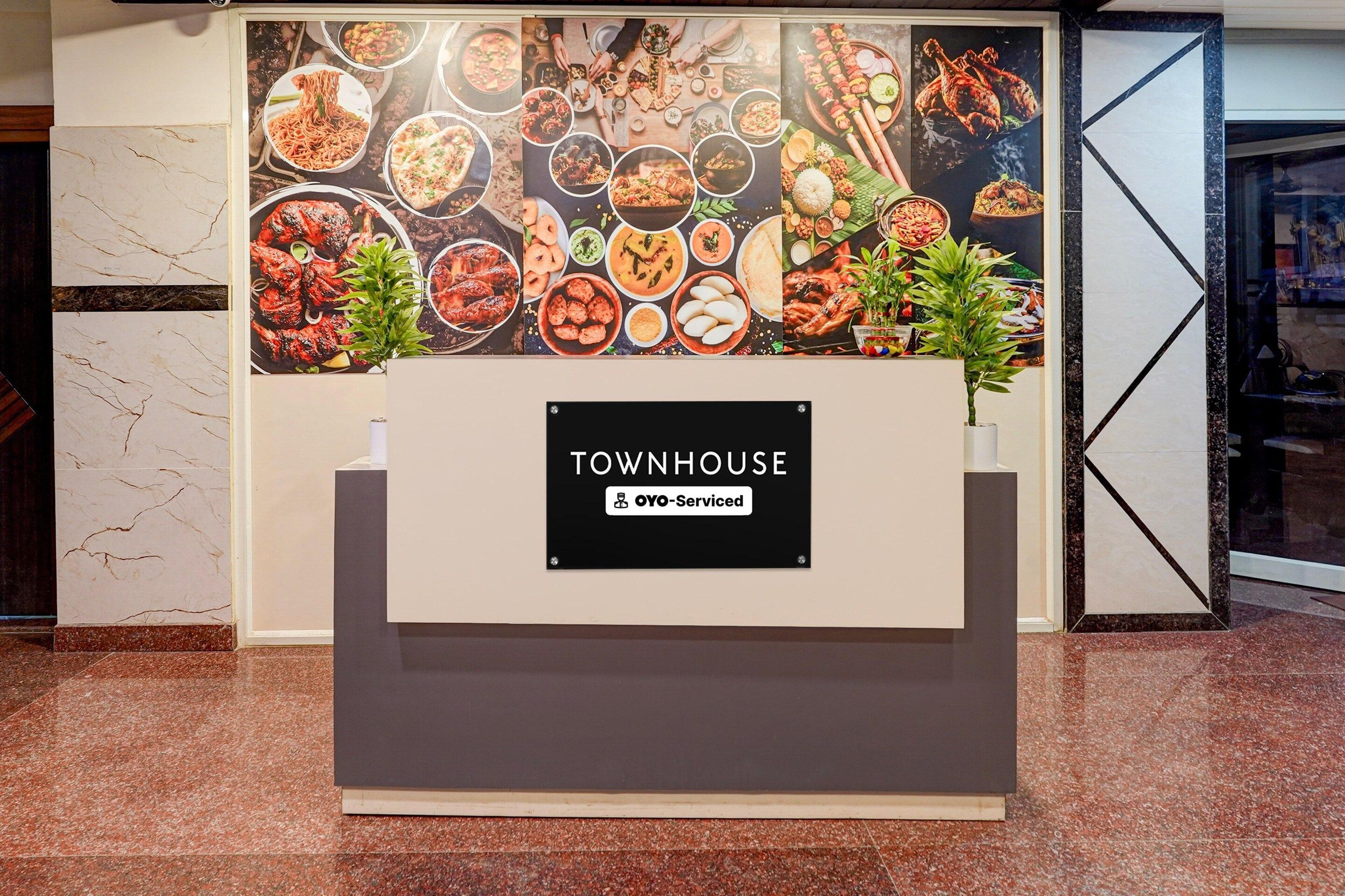 A reception area with a sign for 'TOWNHOUSE' and 'Oyo-Serviced' indicating a serviced hotel.