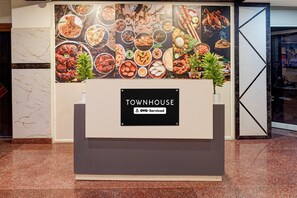 A reception area with a sign for 'TOWNHOUSE' and 'Oyo-Serviced' indicating a serviced hotel.