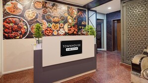 Ein Empfangstisch mit einem Schild, auf dem 'Townhouse' und 'Oyo-Serviced' steht.