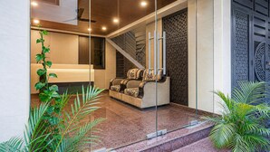Ein modernes Interieur mit Glastrennwand, einer Couch, einer Treppe und dekorativen Wandverkleidungen.