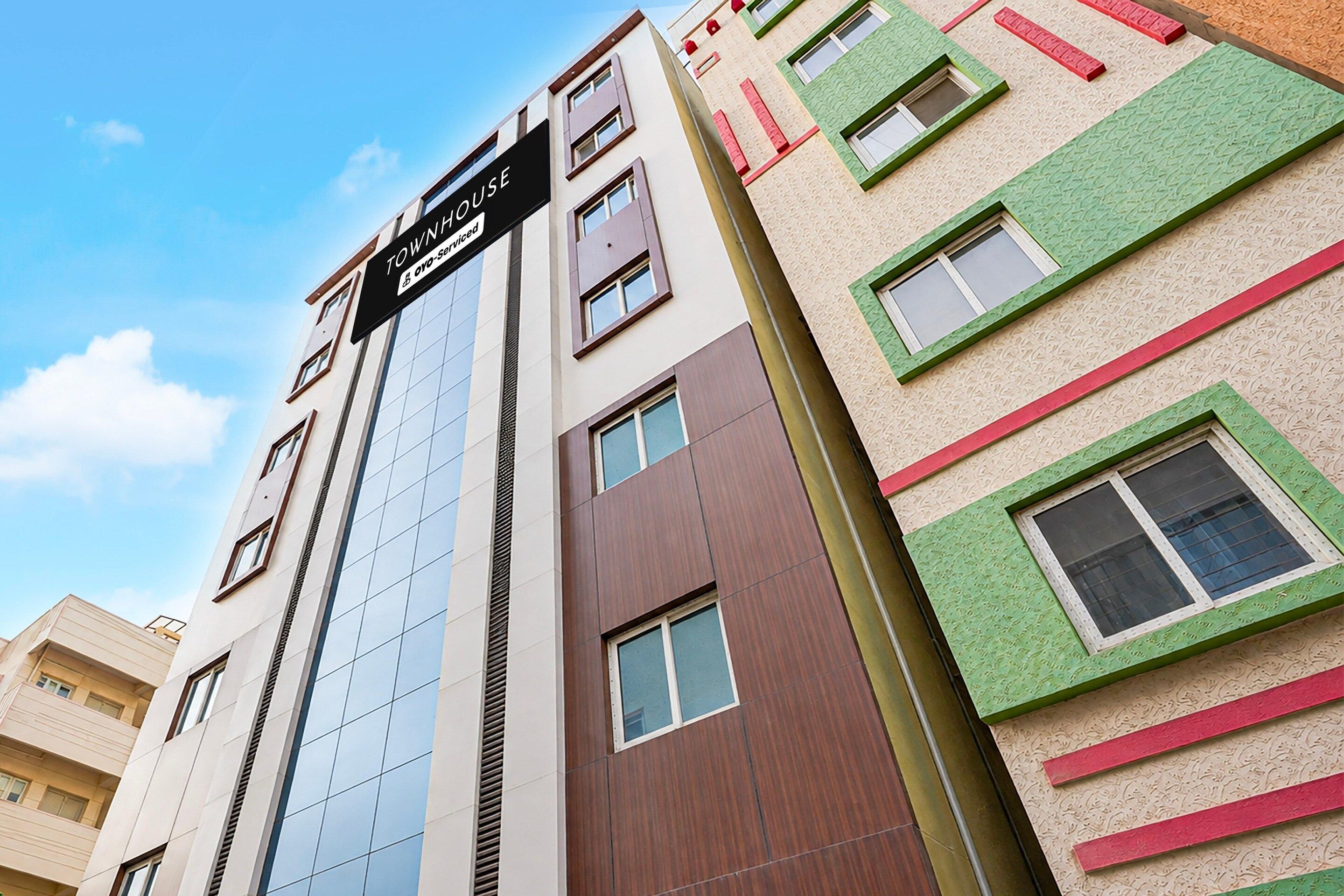 A multi-story building with a sign indicating it is a serviced apartment.