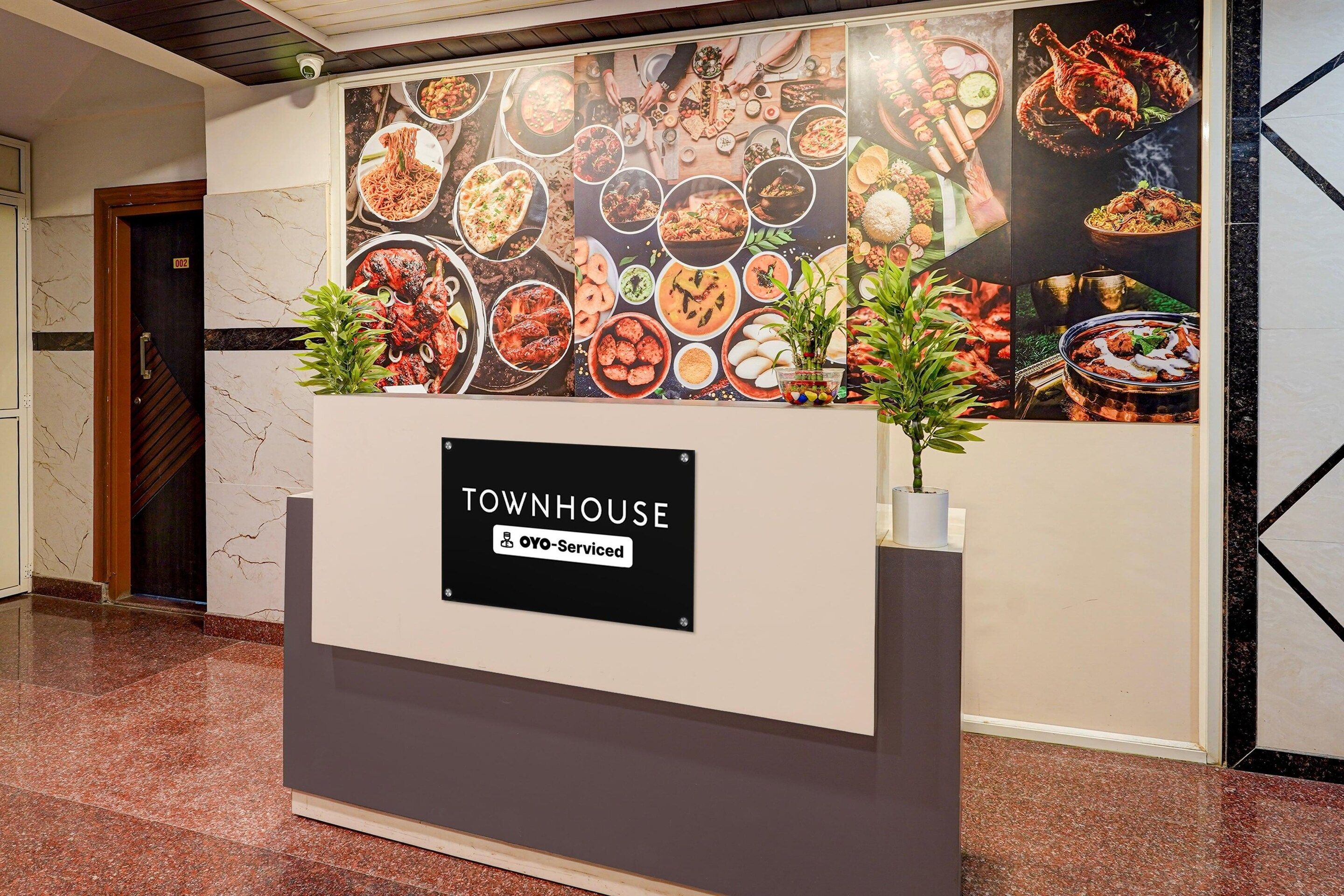 A reception desk with a sign indicating it is serviced by OYO.