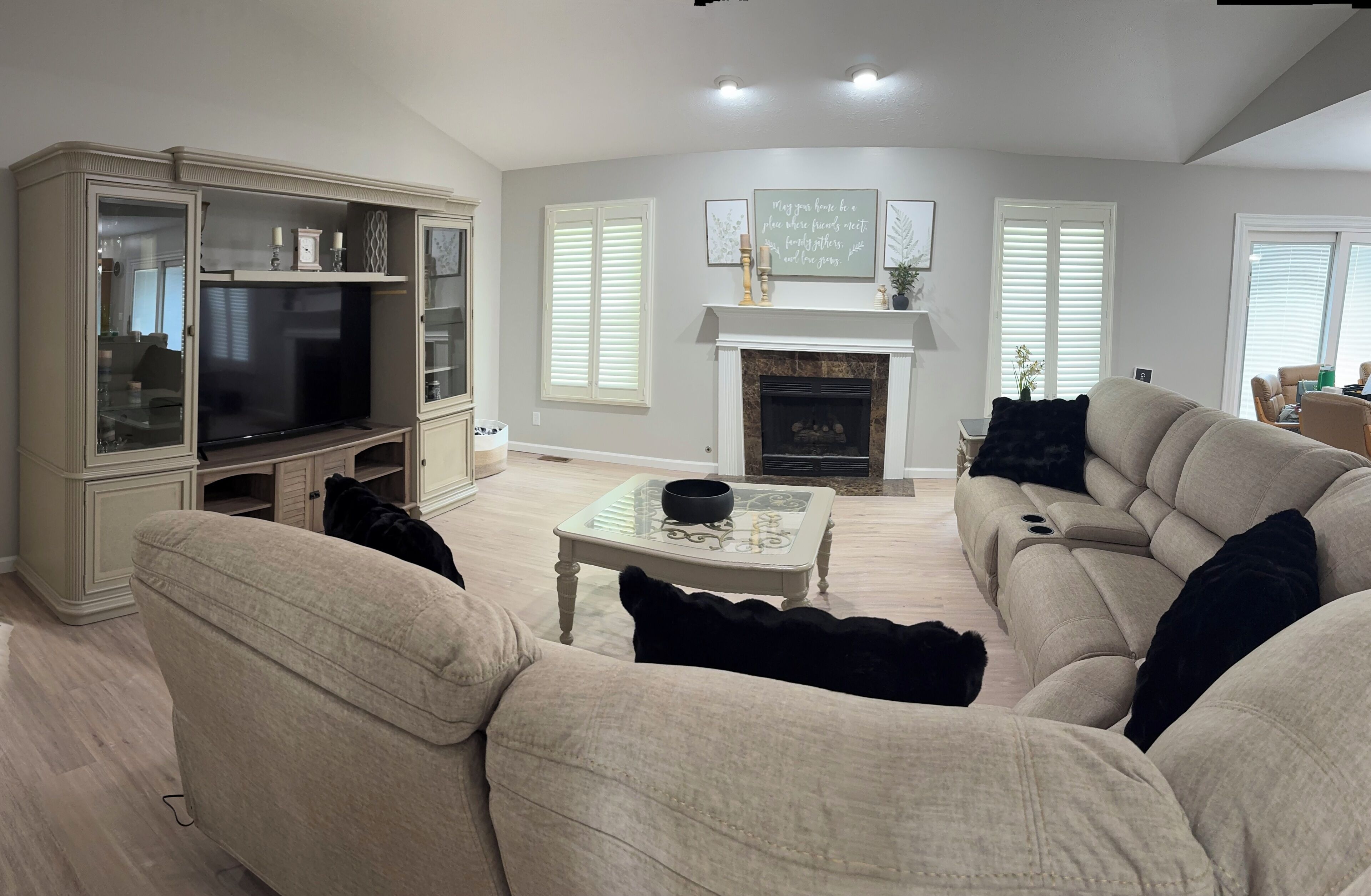 Una sala de estar con chimenea, televisor y sofá.