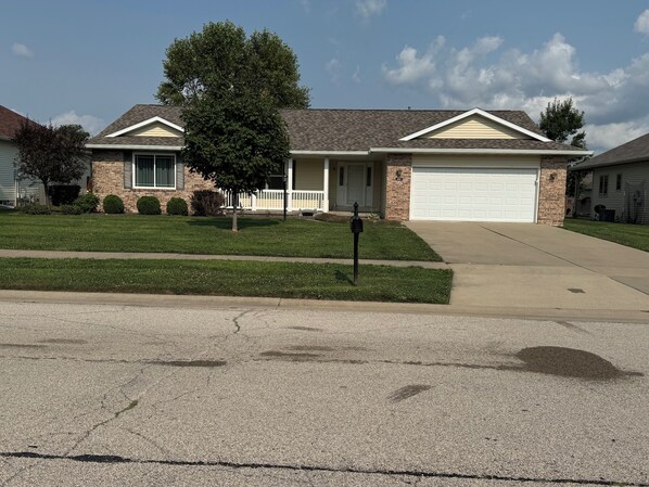 A residential house with a garage, a driveway, and a well-maintained lawn.