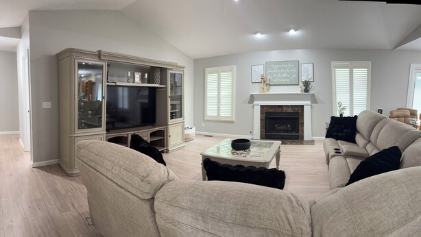 A living room with a fireplace, a television, and a sofa.