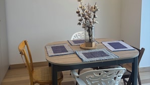 A dining area with a round table, two chairs, and hanging light fixtures. - Cozy, air-conditioned 2-bedroom apartment, Toulon (Toulon)