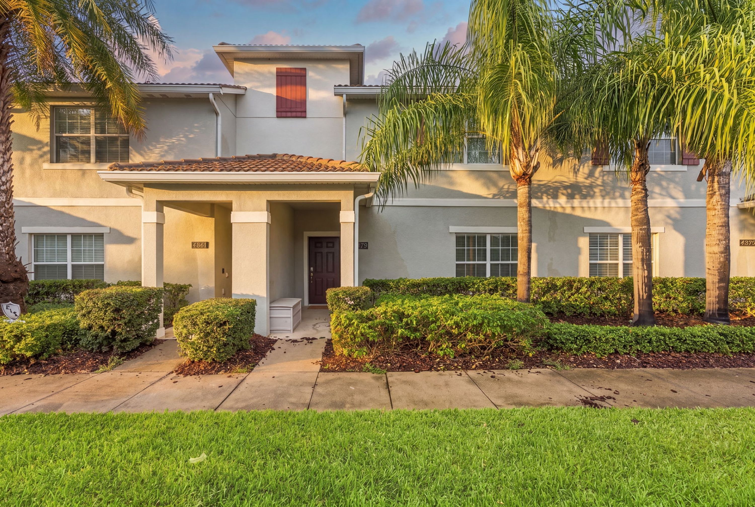 A two-story house with a covered entryway, a front door, and a small porch.