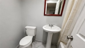 A small bathroom with a toilet, sink, and a mirror above the sink.