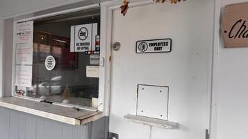 A door with a 'No Smoking' sign, an 'Employees Only' sign, and a small shelf.