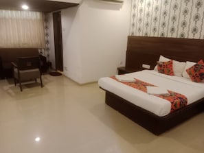 Ein Hotelzimmer mit einem Bett, einem Nachttisch und einem Sessel.
