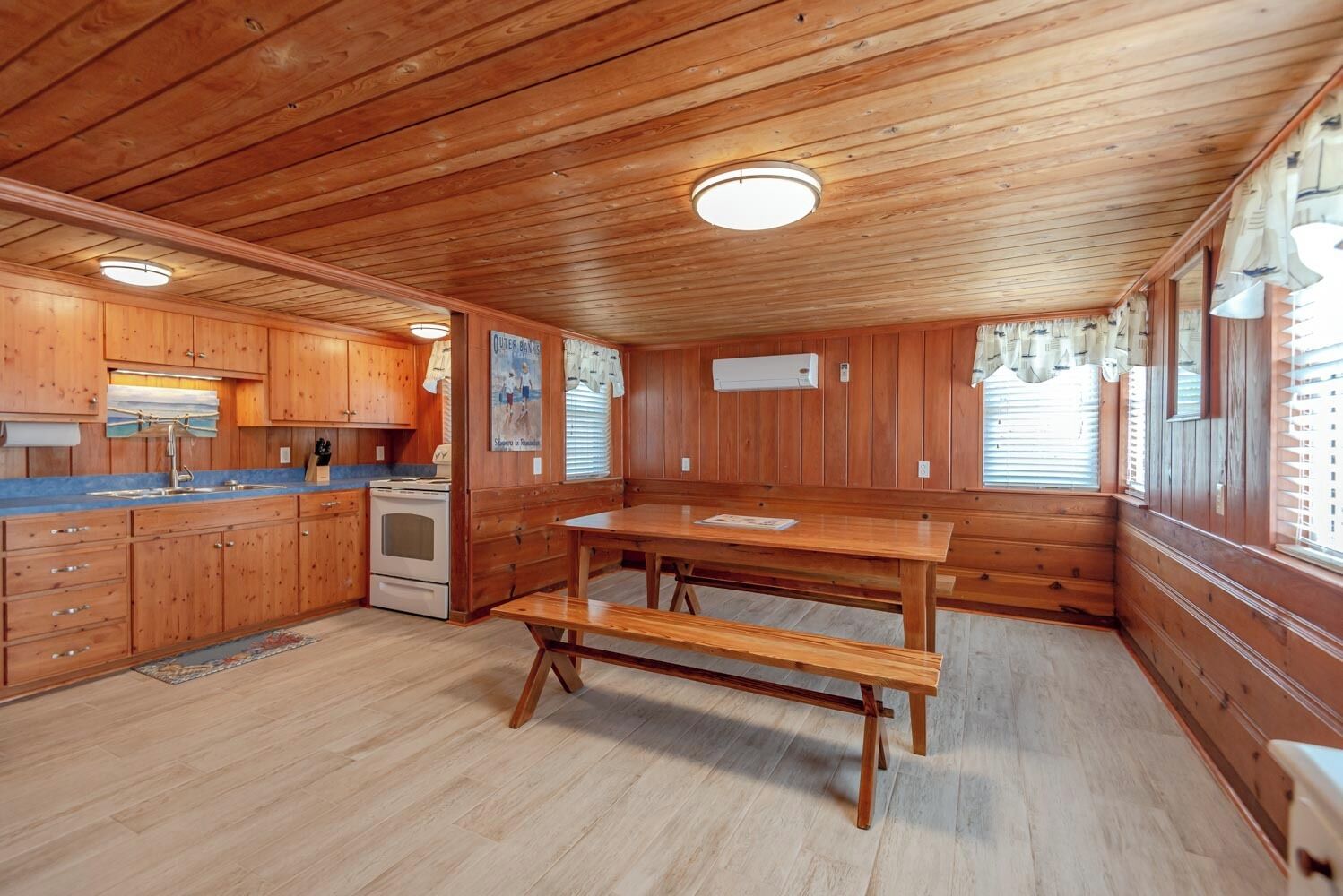 A cabin-style kitchen with wooden cabinets, a central island, and a built-in stove.