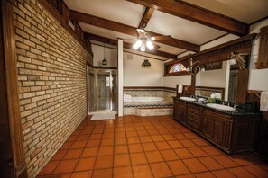 A bathroom with a tiled floor, a shower, a bathtub, and a vanity with a mirror.