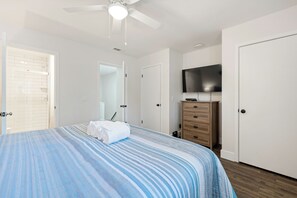 A bedroom with a bed, a television, a dresser, and a ceiling fan. - Remodel Condo overlooks Pool walk to Celebration Park Beach & Coligny! (Hilton Head Island)