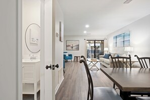Un intérieur moderne comprenant un coin repas, un salon et une vue sur l’extérieur.