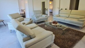 Ein modernes Wohnzimmer mit zwei Sofas, einem Couchtisch und einem Teppich.