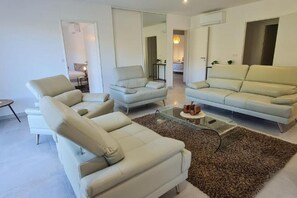 Ein modernes Wohnzimmer mit zwei Sofas, einem Couchtisch und einem Teppich.