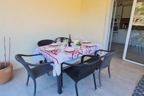 A dining table set for four with a white tablecloth and red patterns, surrounded by wicker chairs. - RIVERFRONT HOME: CASA SOLE E FIUME (PERI)